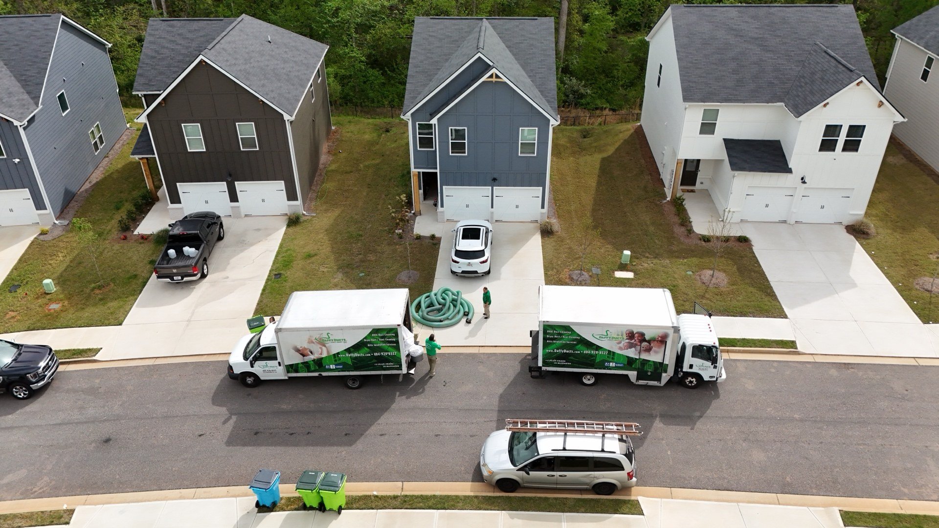 Daffy Ducts service trucks parked back to back at a customer home during Atlanta airflow diagnostics